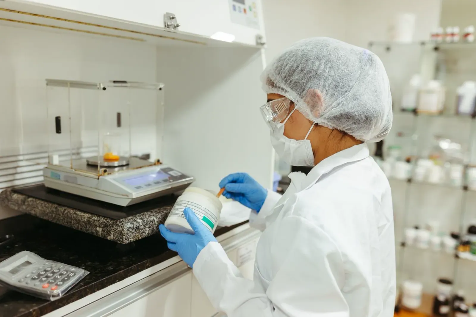 Laboratory technician weighing a sample on a precision balance Fisher Scales Norfolk